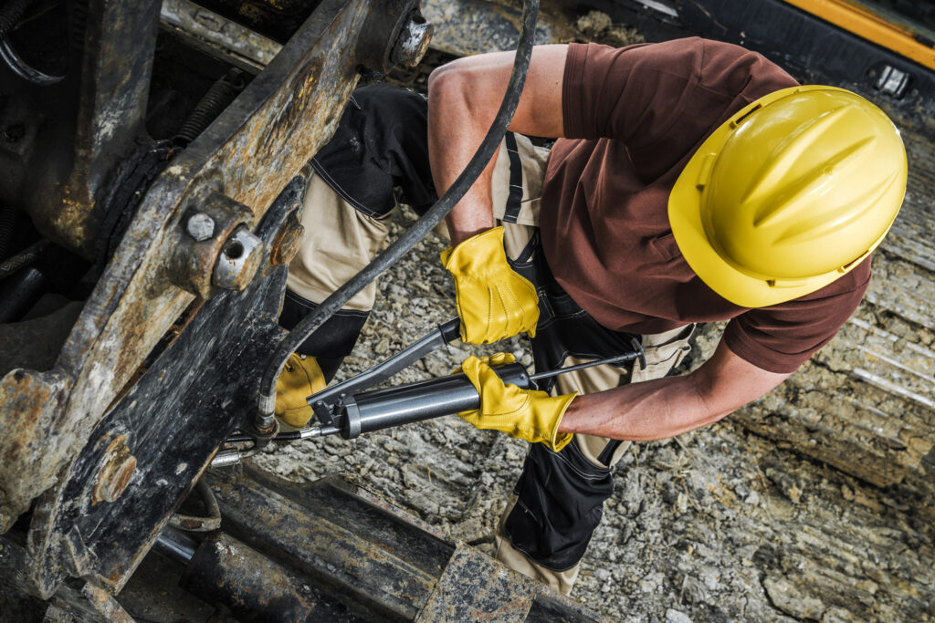 Industrial maintenance worker on site using heavy duty machinery