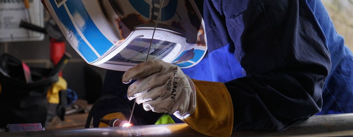 female student learning to weld