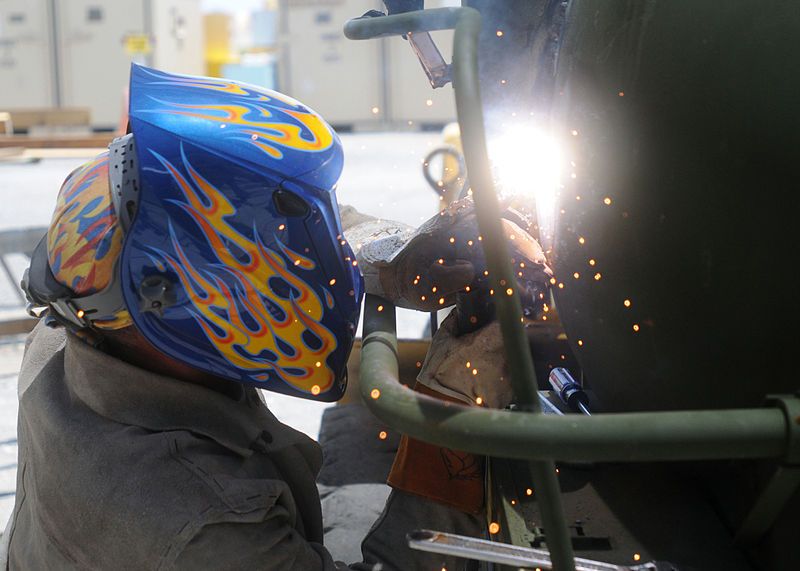 female welder with custom helmet