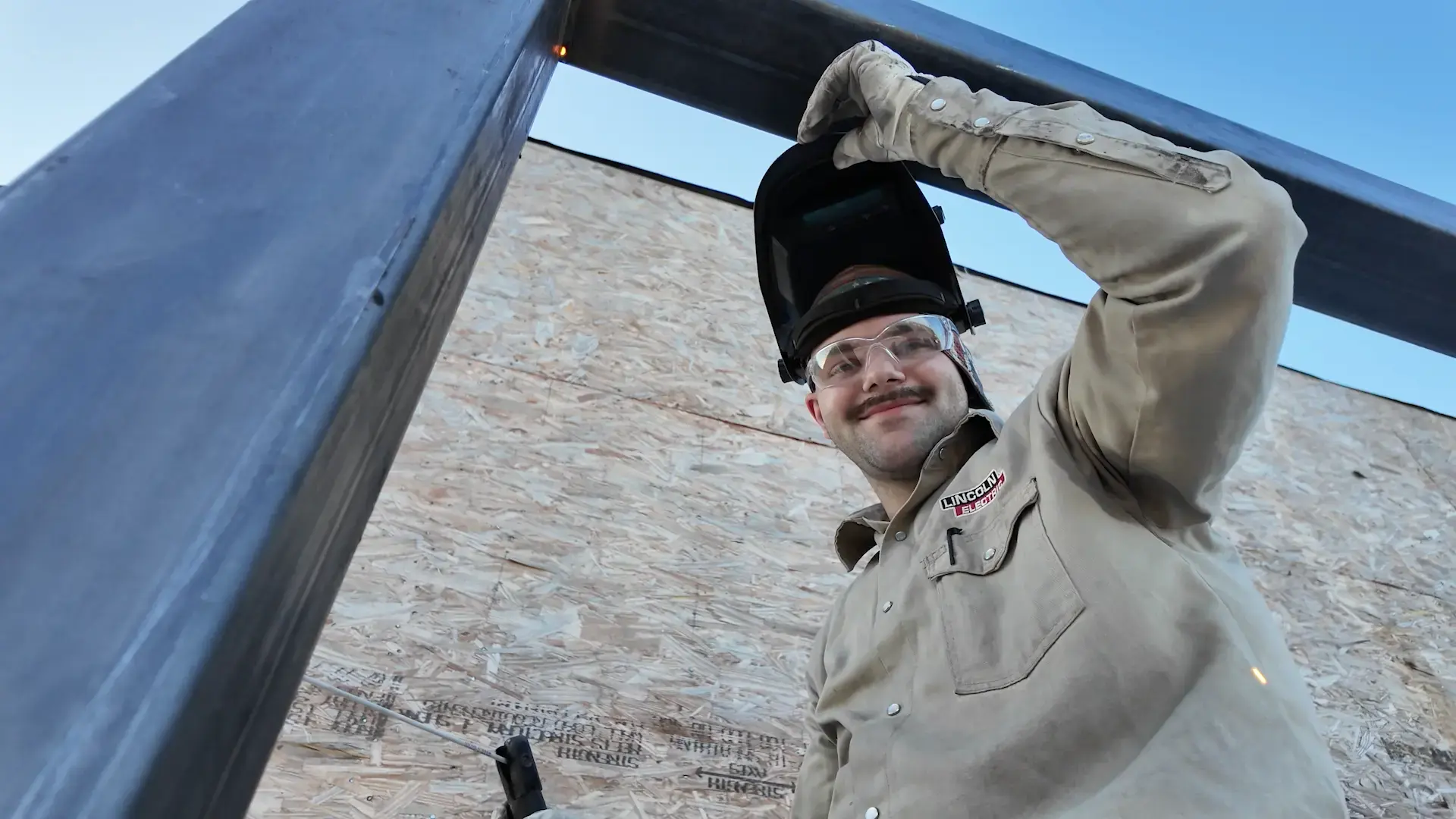 Student flipping his welding mask up
