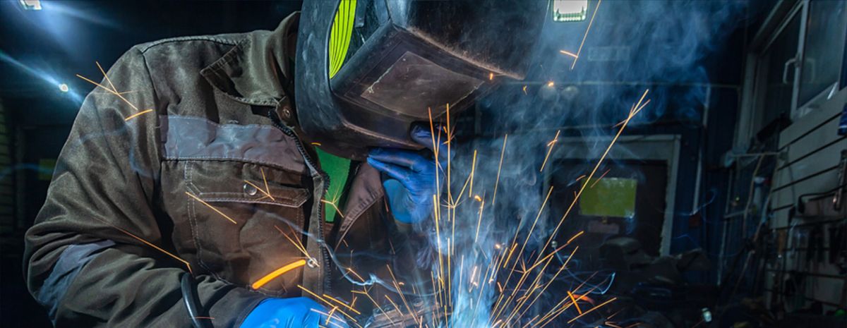 professional welder with sparks hitting helmet